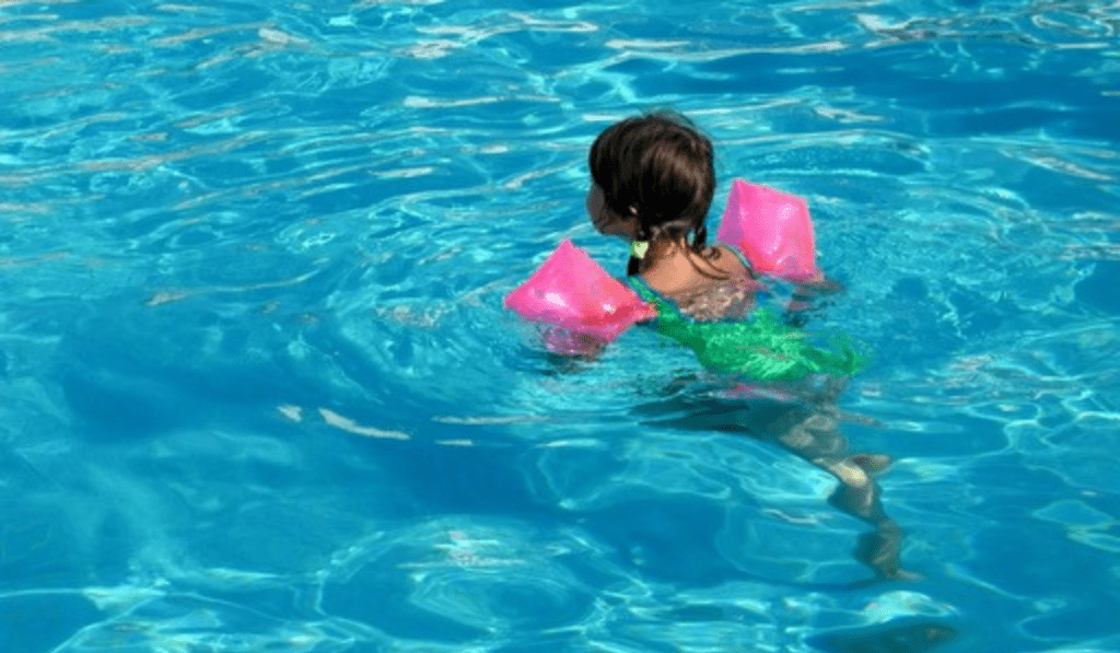 child struggles to kick in floaties
