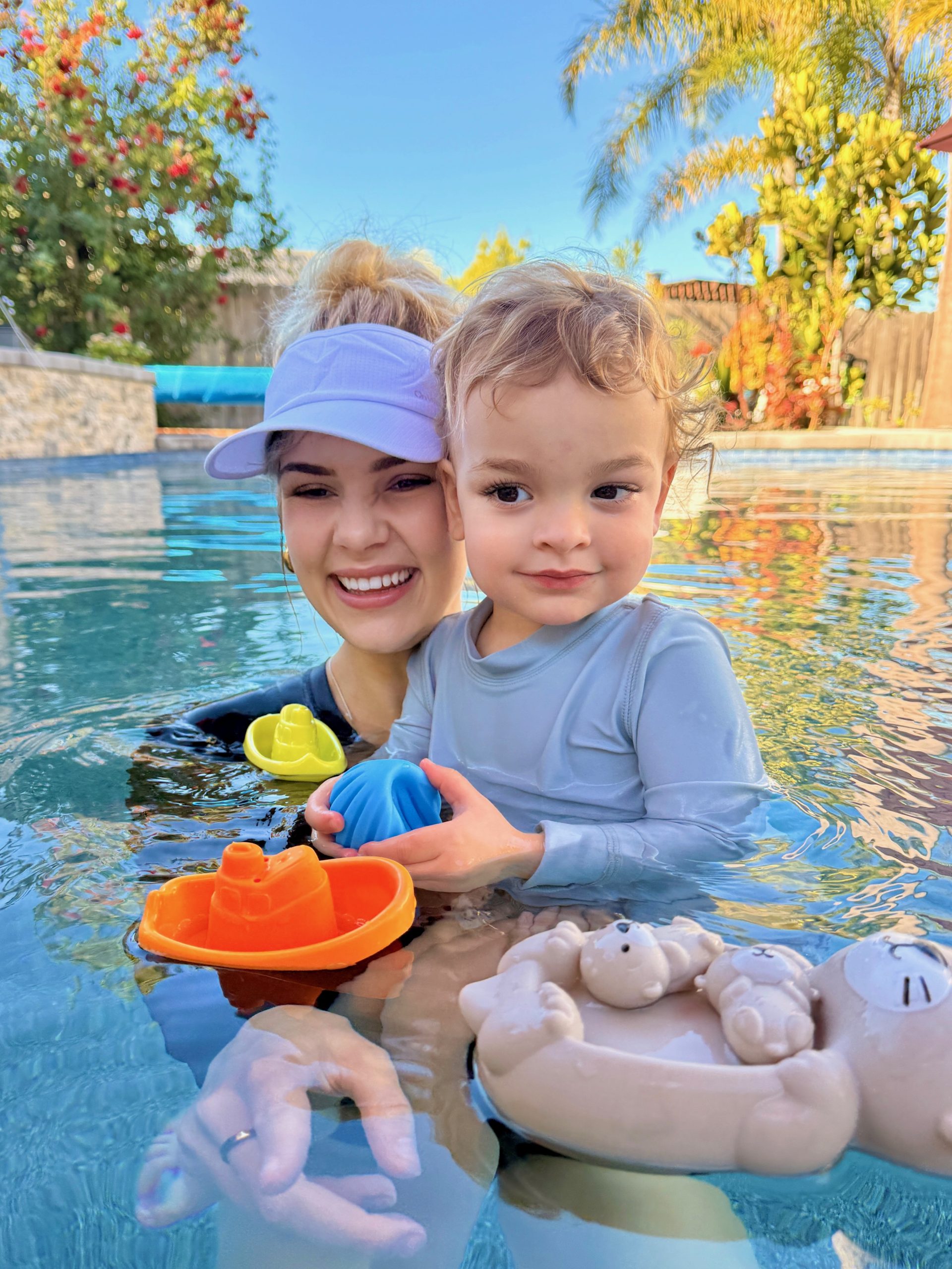 Miss Emma with a young student and pool toys.