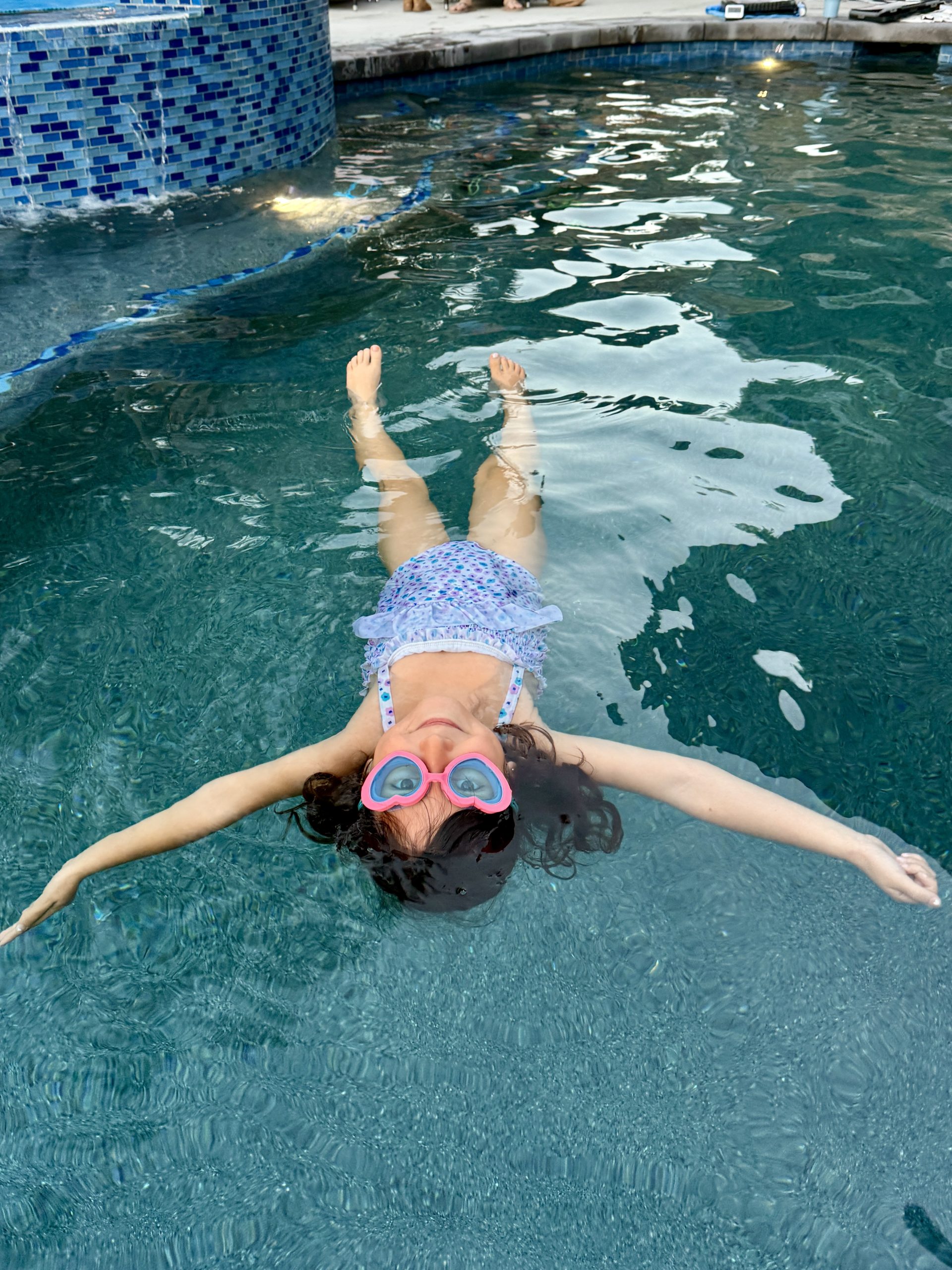 Student practicing a back float in a Swim Synergy pool.
