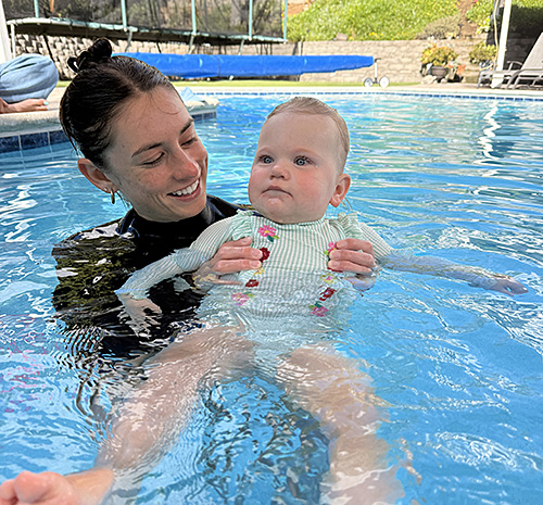 Annika supporting a young swimmer in the pool.