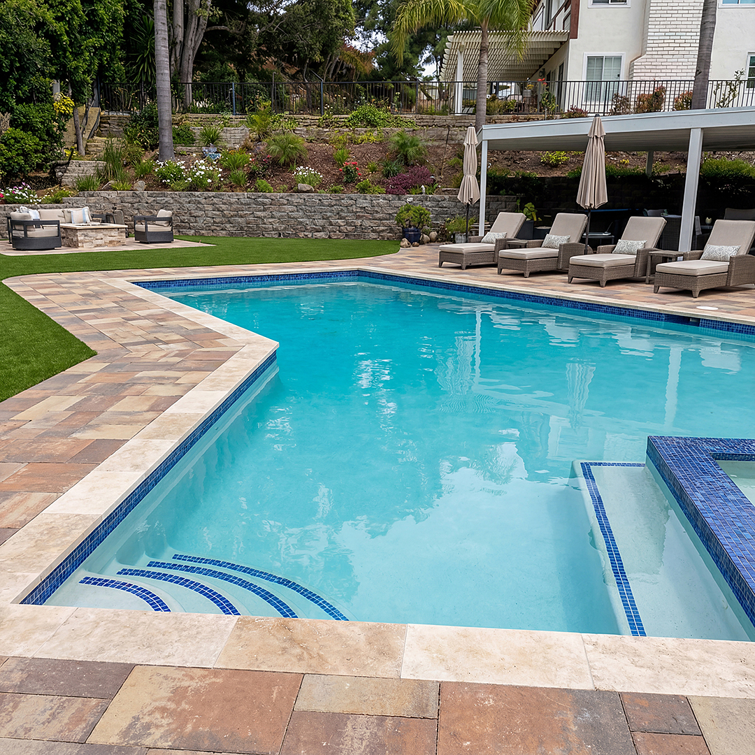 Turquoise pool with tiled entry steps and landscaped poolside seating.